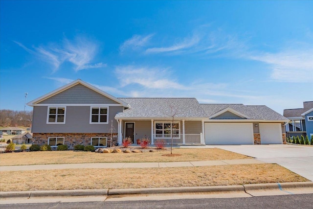 4062 Red Hawk Run, Black Earth, WI 53515 - tri-level home with a porch, a garage, stone siding, and concrete driveway