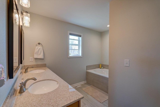 4062 Red Hawk Run, Black Earth, WI 53515 - bathroom with double vanity, a garden tub, baseboards, and a sink