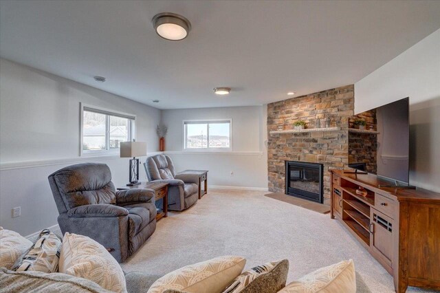 4062 Red Hawk Run, Black Earth, WI 53515 - living area featuring light carpet, a stone fireplace, and baseboards