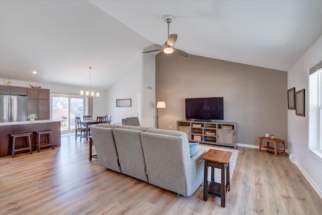 4062 Red Hawk Run, Black Earth, WI 53515 - living area featuring high vaulted ceiling, light wood-style flooring, ceiling fan with notable chandelier, and baseboards