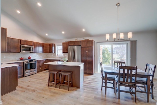 4062 Red Hawk Run, Black Earth, WI 53515 - kitchen with backsplash, light wood-type flooring, a kitchen island, and stainless steel appliances