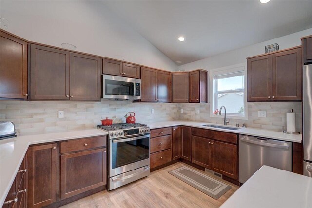 4062 Red Hawk Run, Black Earth, WI 53515 - kitchen featuring lofted ceiling, light countertops, a sink, and appliances with stainless steel finishes