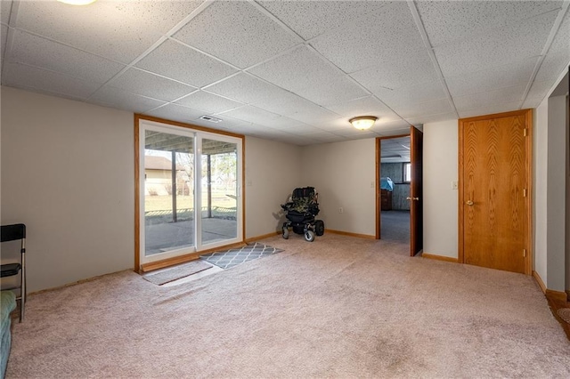 carpeted spare room featuring a paneled ceiling