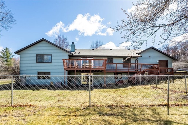 rear view of house with a yard, a deck, a fenced backyard, and a chimney