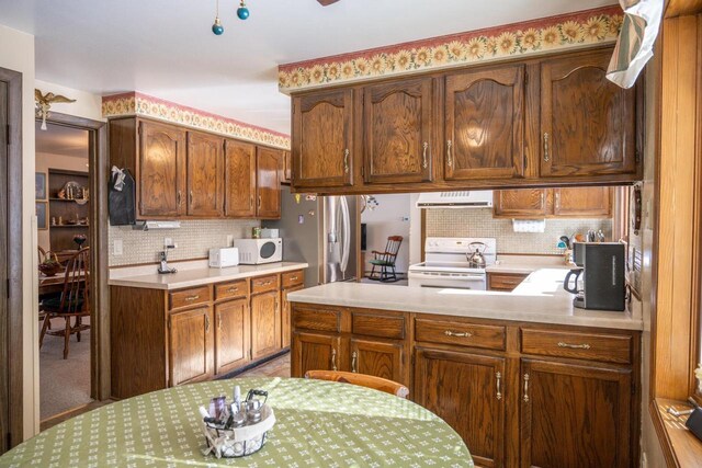 W5384 25th St, Necedah, WI 54646 - kitchen with light countertops, decorative backsplash, exhaust hood, and white appliances