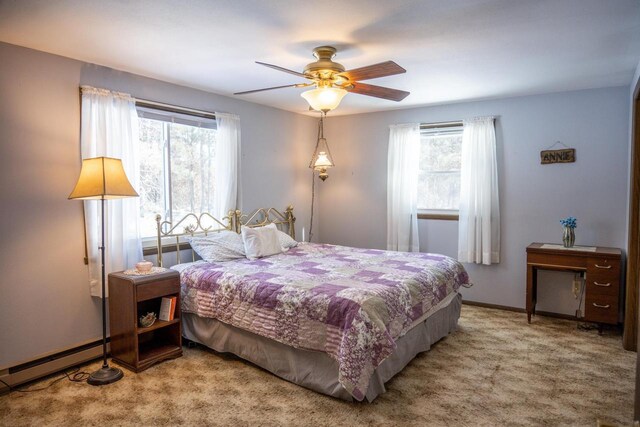 W5384 25th St, Necedah, WI 54646 - carpeted bedroom featuring a baseboard radiator, ceiling fan, baseboards, and multiple windows