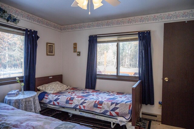 W5384 25th St, Necedah, WI 54646 - bedroom with baseboard heating, a ceiling fan, and multiple windows