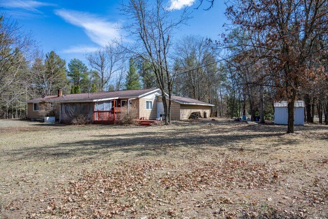 W5384 25th St, Necedah, WI 54646 - view of front of home featuring a wooden deck, a chimney, an outbuilding, and a storage unit