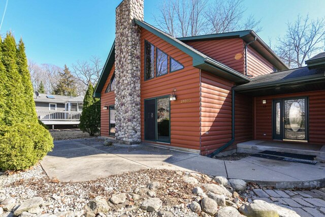 29323 Riverview Ln, Waterford, WI 53185 - exterior space with a patio, a chimney, and faux log siding
