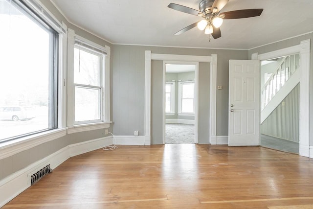 spare room featuring crown molding, visible vents, a wealth of natural light, and hardwood / wood-style flooring