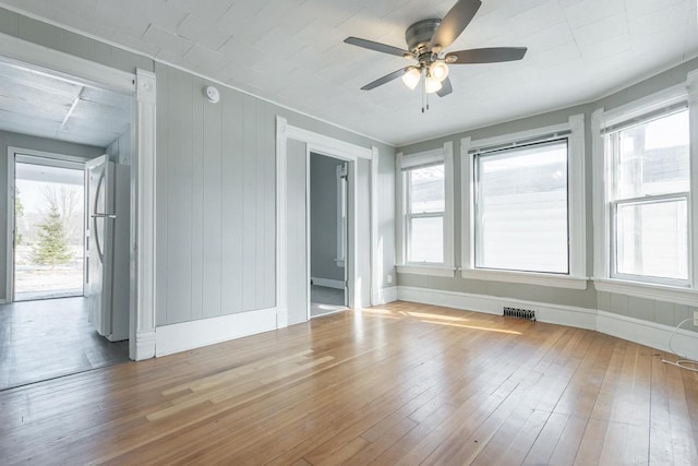 empty room featuring plenty of natural light, visible vents, and ceiling fan