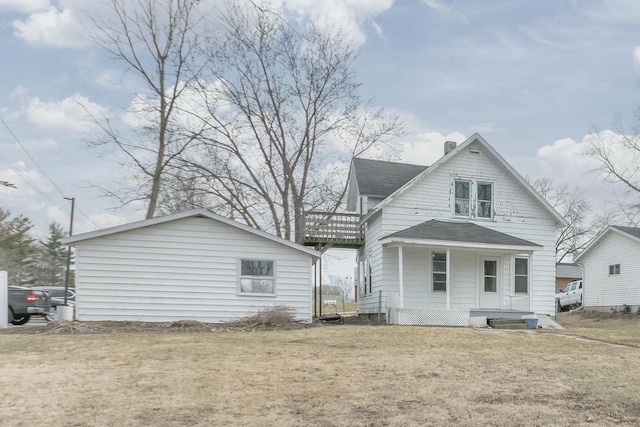rear view of property featuring a porch, roof with shingles, a yard, and a chimney