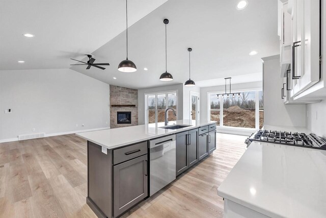 1377 Shelby Ln, De Pere, WI 54115 - kitchen with a fireplace, light countertops, visible vents, dishwasher, and a sink