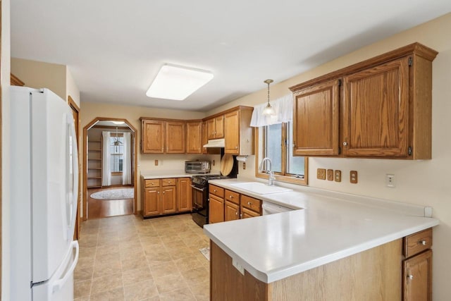 kitchen with a sink, light countertops, arched walkways, white appliances, and brown cabinetry