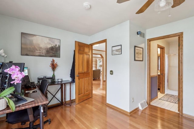 home office with a ceiling fan, visible vents, baseboards, and light wood-type flooring