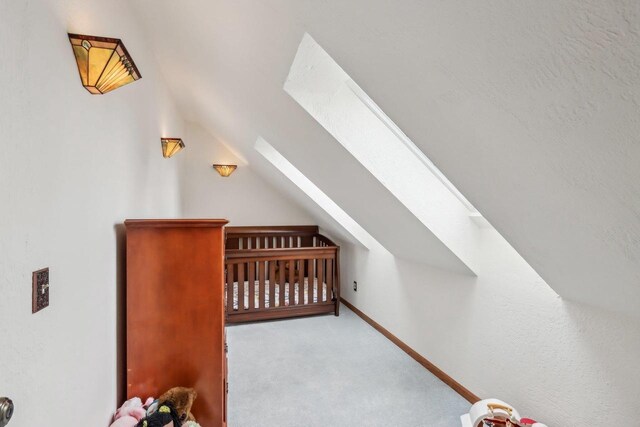 bonus room with carpet and vaulted ceiling with skylight