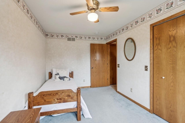 carpeted bedroom with visible vents, a ceiling fan, and baseboards