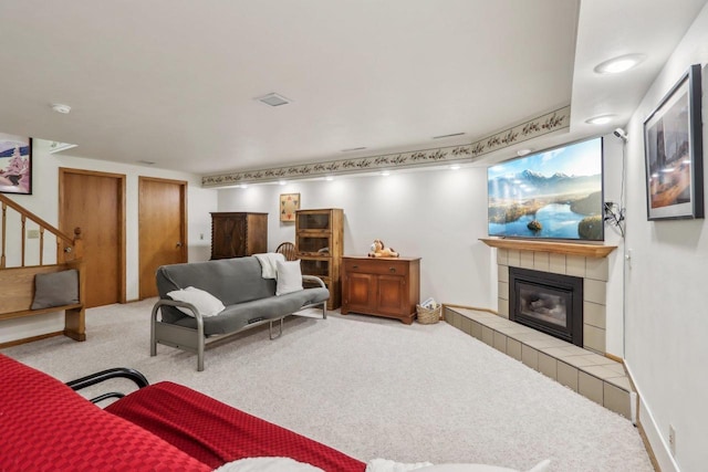 carpeted living room with stairway and a fireplace