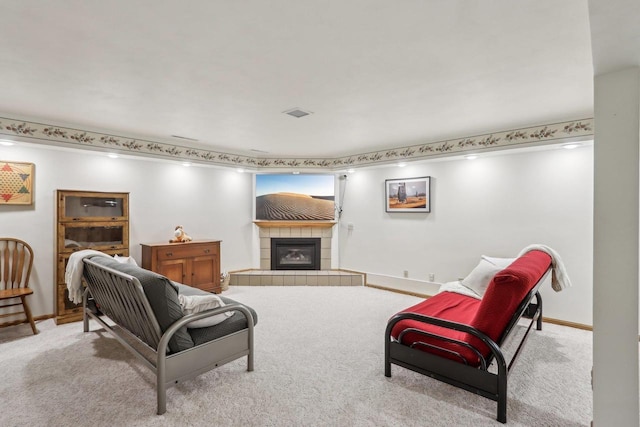 carpeted living room with a tiled fireplace and baseboards