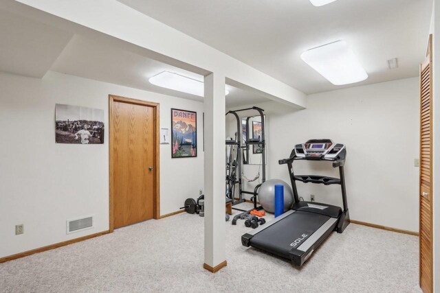 workout room featuring baseboards, visible vents, and carpet floors