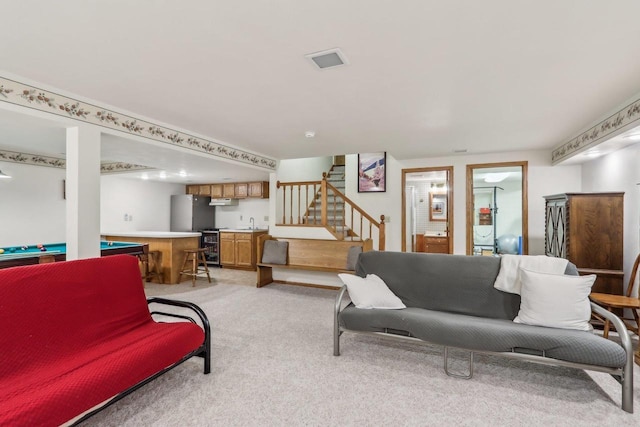 living room with indoor wet bar, visible vents, stairway, and light carpet