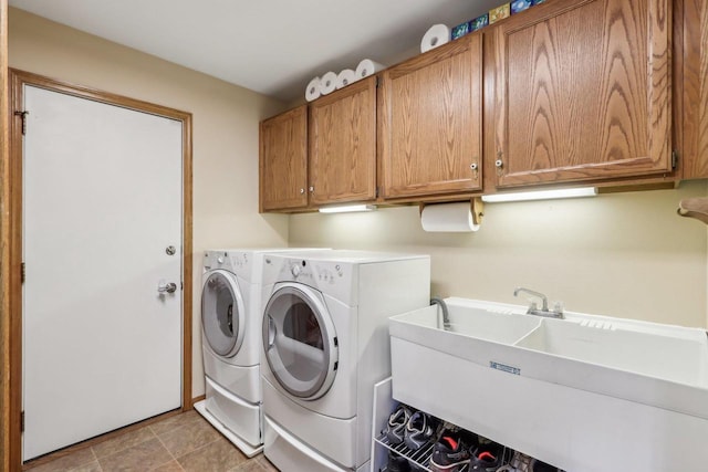 washroom with a sink, cabinet space, and independent washer and dryer