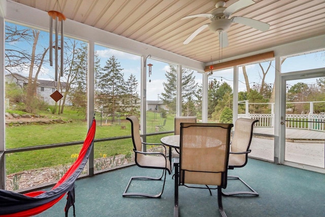 sunroom / solarium featuring a ceiling fan and outdoor dining space
