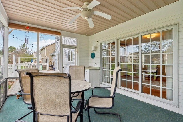 sunroom with outdoor dining space, a ceiling fan, and plenty of natural light