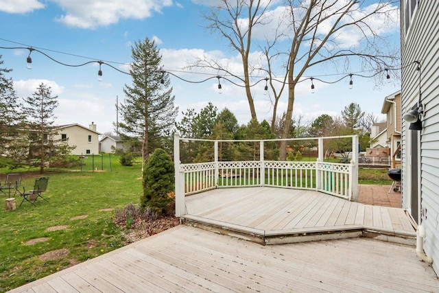wooden deck with a lawn and fence