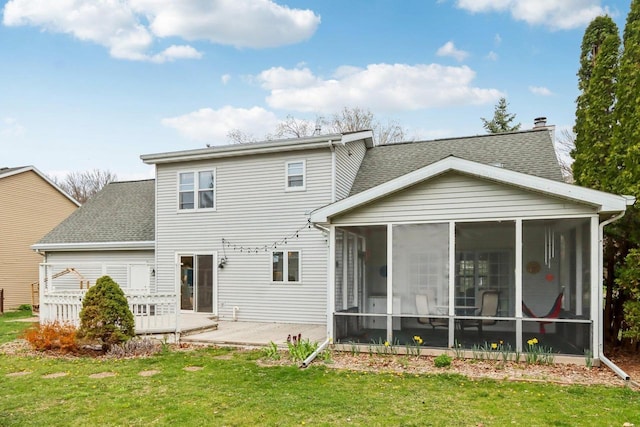 back of house with a lawn, a shingled roof, and a sunroom
