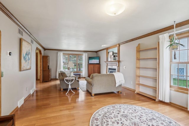 living area featuring light wood finished floors, visible vents, and plenty of natural light