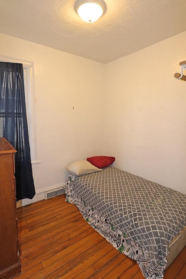 bedroom with wood finished floors, baseboards, and visible vents