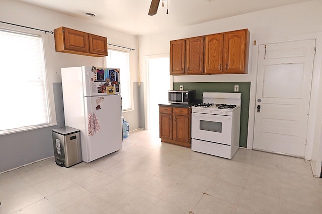 kitchen featuring visible vents, brown cabinetry, white appliances, and ceiling fan