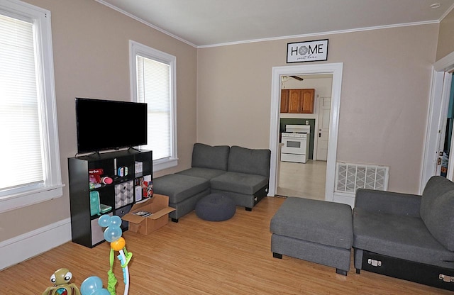 living area with ornamental molding, visible vents, and light wood-type flooring