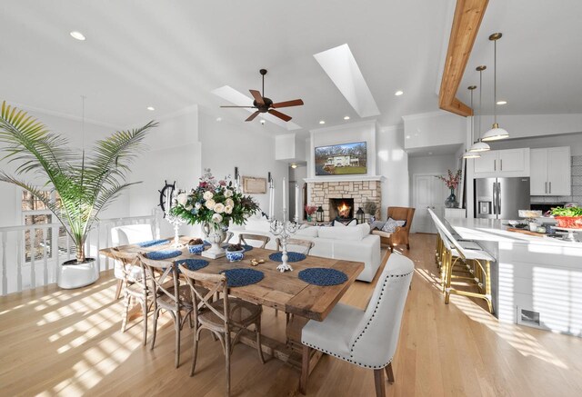 1066 Edinborough Ct, Lake Geneva, WI 53147 - dining area featuring a ceiling fan, a stone fireplace, light wood-type flooring, and lofted ceiling