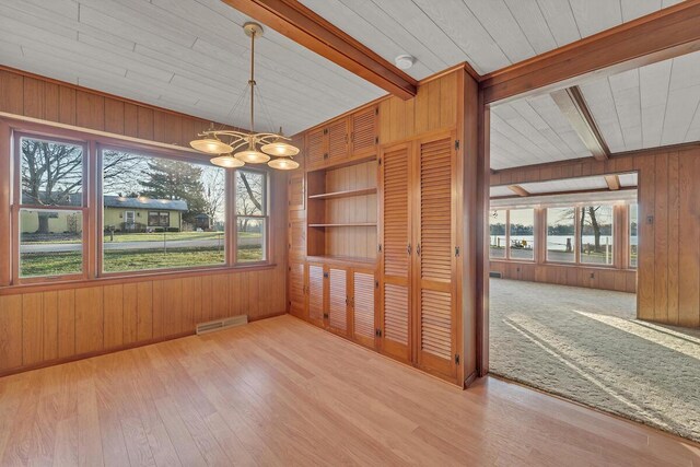 12606 234th Ave, Trevor, WI 53179 - unfurnished dining area featuring wooden walls, a chandelier, and a healthy amount of sunlight