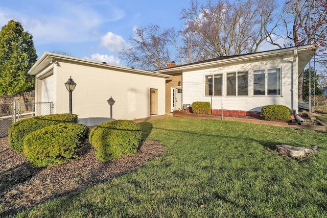 12606 234th Ave, Trevor, WI 53179 - ranch-style house with a front yard, concrete block siding, fence, and a chimney