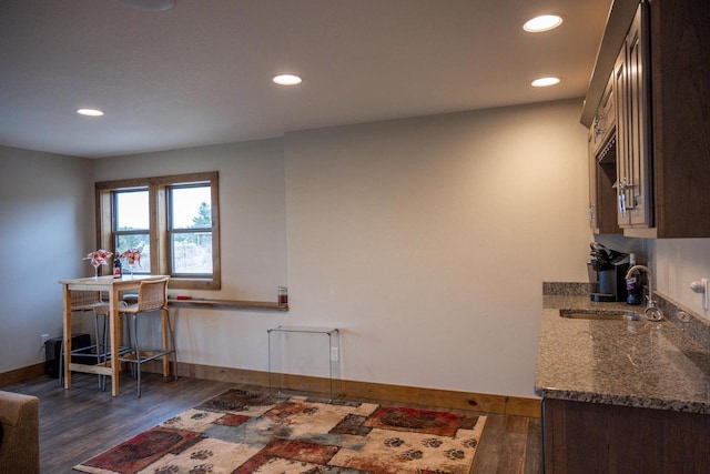 W5677 N Stone Gate Dr, New Lisbon, WI 53950 - kitchen featuring recessed lighting, dark wood-style flooring, a sink, and dark stone counters