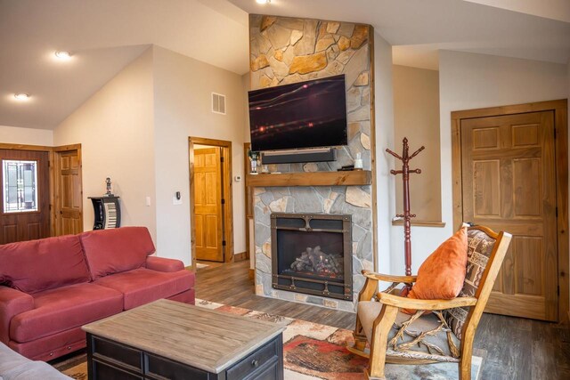 W5677 N Stone Gate Dr, New Lisbon, WI 53950 - living room featuring visible vents, a stone fireplace, vaulted ceiling, and wood finished floors
