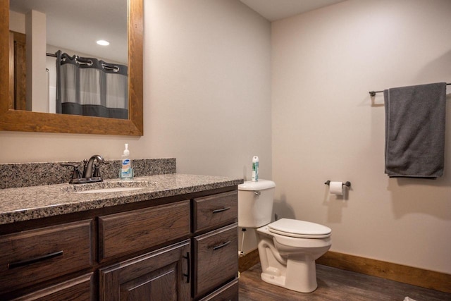 W5677 N Stone Gate Dr, New Lisbon, WI 53950 - full bathroom featuring vanity, baseboards, curtained shower, toilet, and wood finished floors