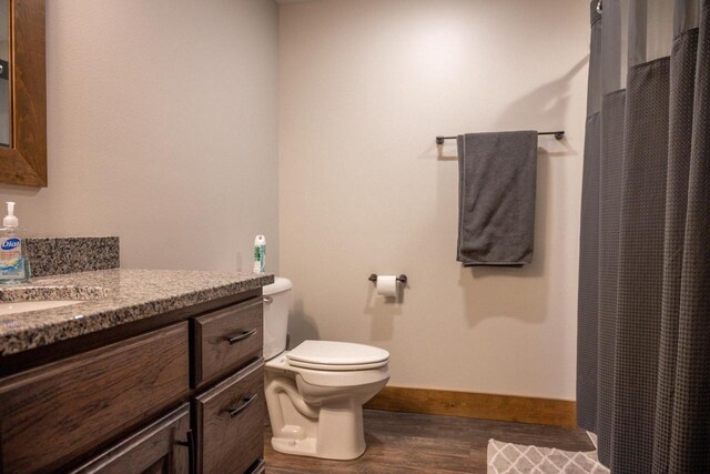 W5677 N Stone Gate Dr, New Lisbon, WI 53950 - bathroom featuring vanity, baseboards, curtained shower, toilet, and wood finished floors