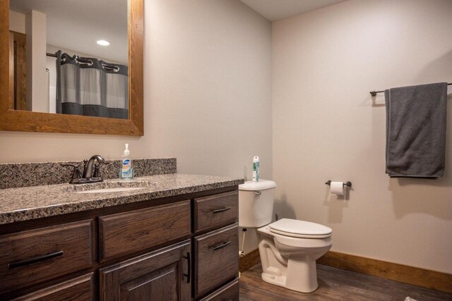 W5677 N Stone Gate Dr, New Lisbon, WI 53950 - full bathroom featuring vanity, baseboards, curtained shower, toilet, and wood finished floors