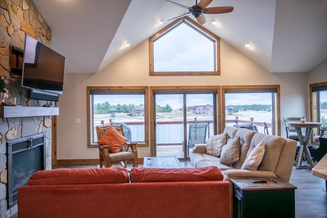 W5677 N Stone Gate Dr, New Lisbon, WI 53950 - living room with baseboards, a stone fireplace, a ceiling fan, lofted ceiling, and wood finished floors