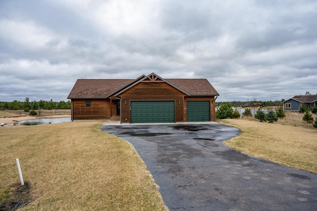 W5677 N Stone Gate Dr, New Lisbon, WI 53950 - view of front of property featuring a garage, a water view, roof with shingles, a front yard, and driveway