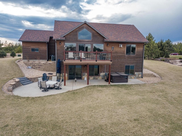 W5677 N Stone Gate Dr, New Lisbon, WI 53950 - back of property featuring a yard, a hot tub, roof with shingles, and a patio
