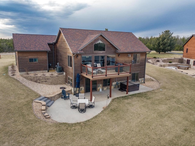 W5677 N Stone Gate Dr, New Lisbon, WI 53950 - rear view of property featuring a shingled roof, a patio area, a lawn, and central AC
