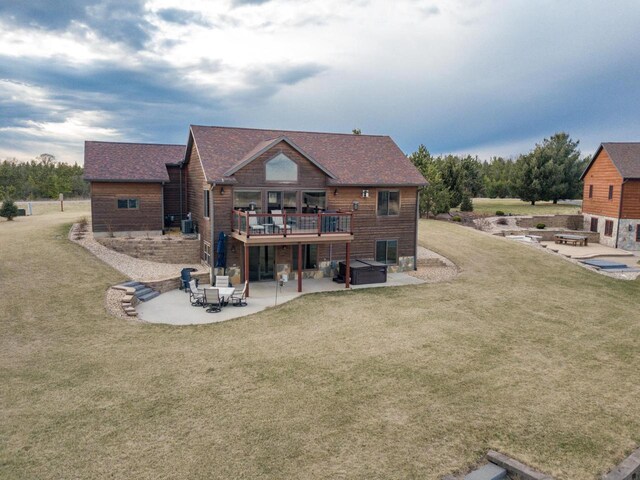 W5677 N Stone Gate Dr, New Lisbon, WI 53950 - rear view of house featuring a lawn, a fire pit, a hot tub, and a patio