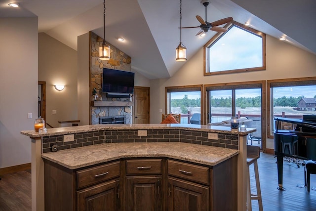 W5677 N Stone Gate Dr, New Lisbon, WI 53950 - kitchen featuring dark wood-type flooring, open floor plan, a stone fireplace, and a ceiling fan