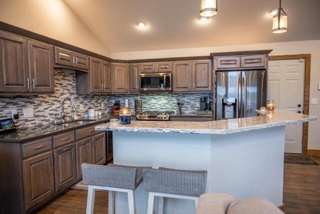 W5677 N Stone Gate Dr, New Lisbon, WI 53950 - kitchen with tasteful backsplash, dark wood-style flooring, vaulted ceiling, stainless steel appliances, and a sink