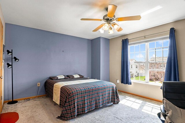 carpeted bedroom featuring baseboards and ceiling fan